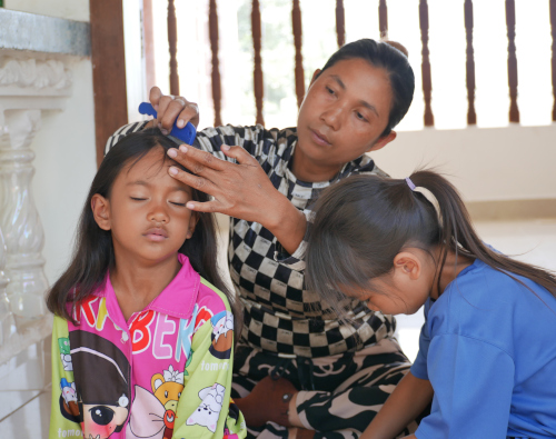 une femme brosse les cheveux d'une petite fille