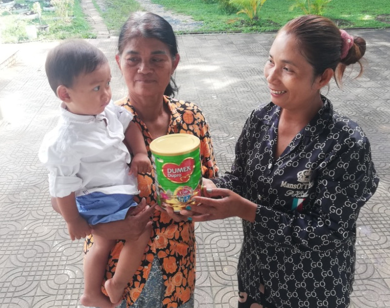 Une femme cambodgienne et son enfant reçoivent un don