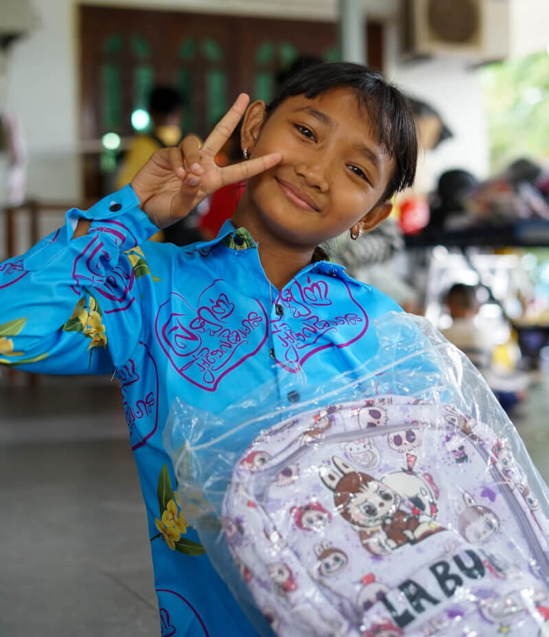 A Cambodian child holding a school bag