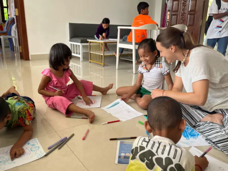 A volunteer with Cambodian children at an art workshop